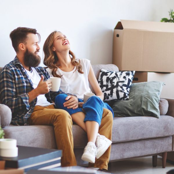 a happy young married couple moves to new apartment